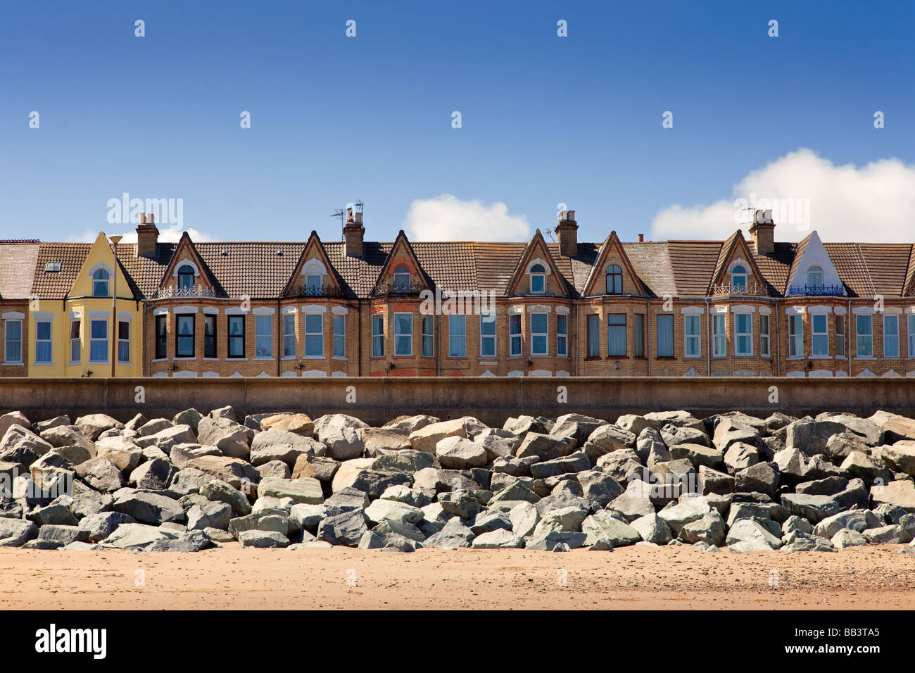 Houses protected by sea defences a sea wall and granite boulders at Withernsea, East Yorkshire, England, UK Stock Photo
