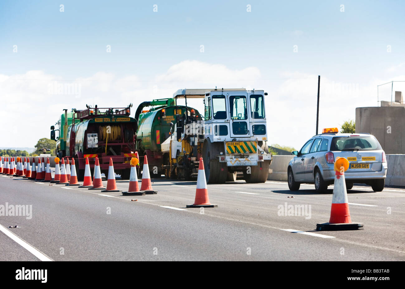Motorway maintenance vehicles in a coned off section of a motorway England UK Stock Photo