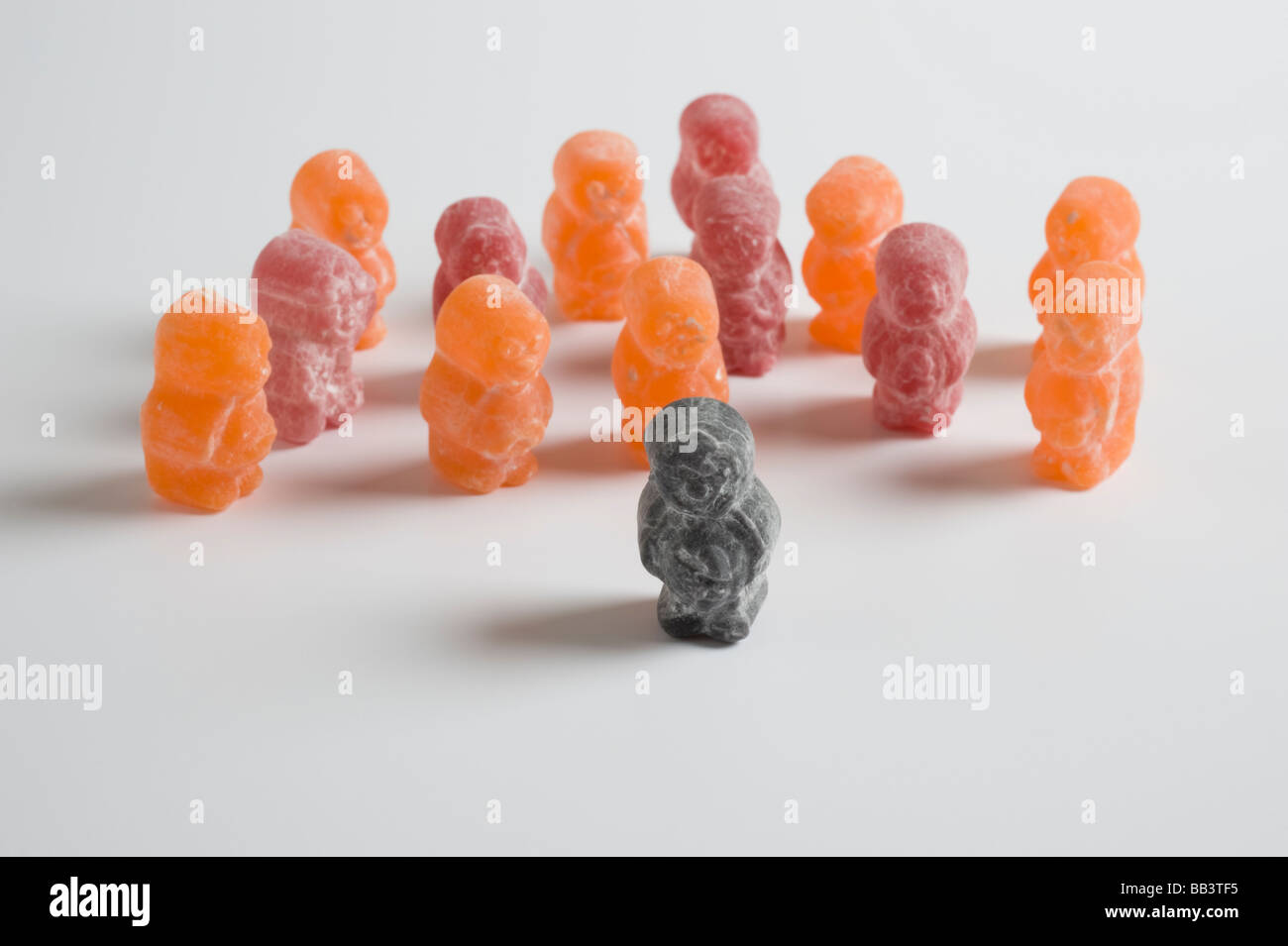 Black jelly baby walking away from or leading group Stock Photo Alamy