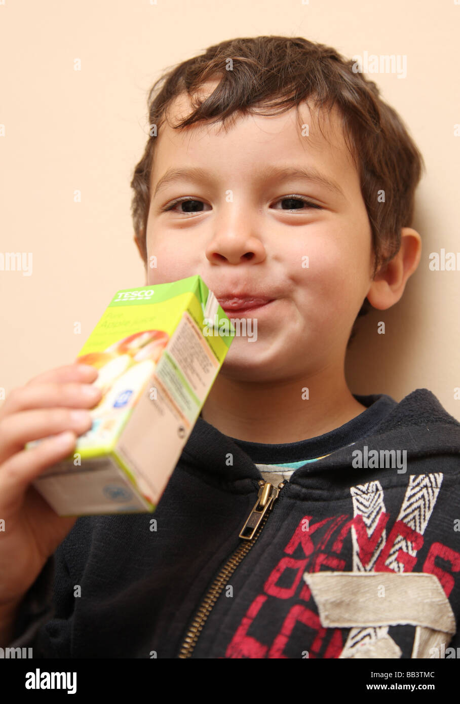 3 year old boy drinking a carton of juice Stock Photo