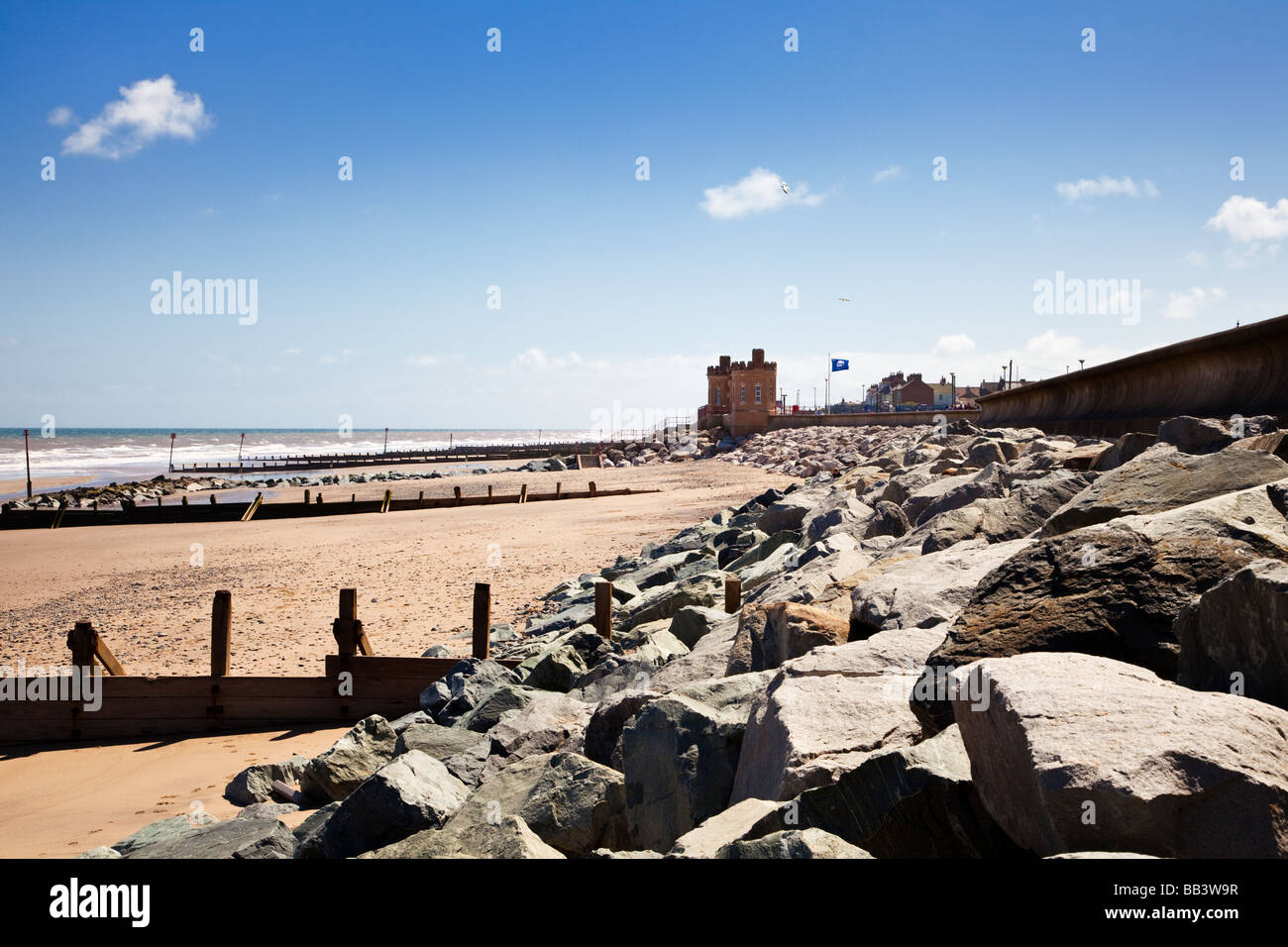 Old Pier Towers and granite boulder protection for the sea wall at Withernsea beach, East Yorkshire, England UK Stock Photo