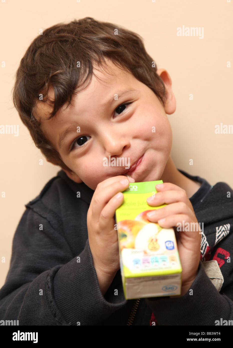 3 year old boy drinking a carton of juice Stock Photo