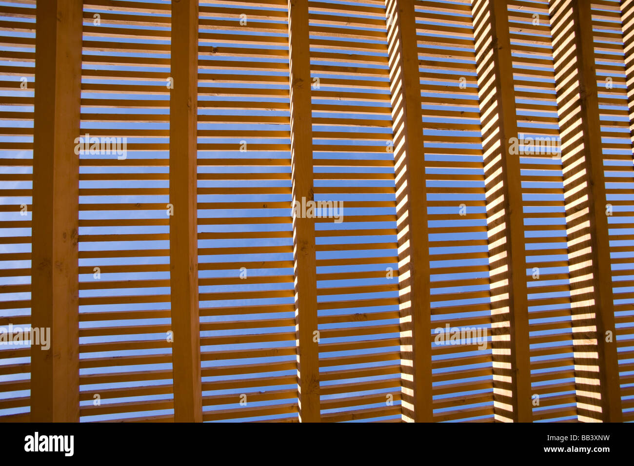 NA, USA, New Mexico, Santa Fe, Museum Hill, MilnerPlaza, Sunlight filtering through wooden lattice structure Stock Photo