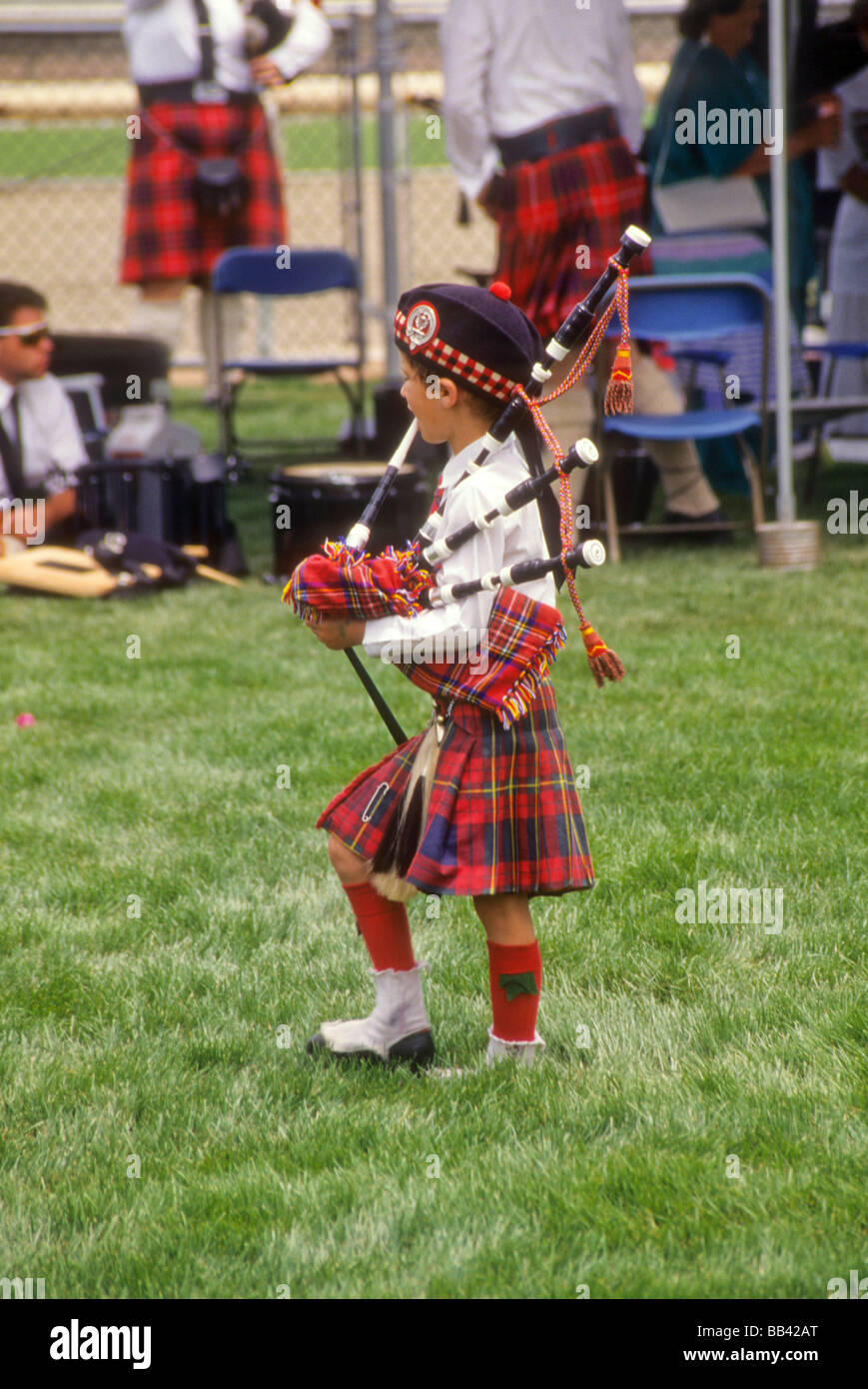 Boy kilt bagpipe play music march dance culture Irish Scotch show exhibit compete demonstrate history talent band Stock Photo
