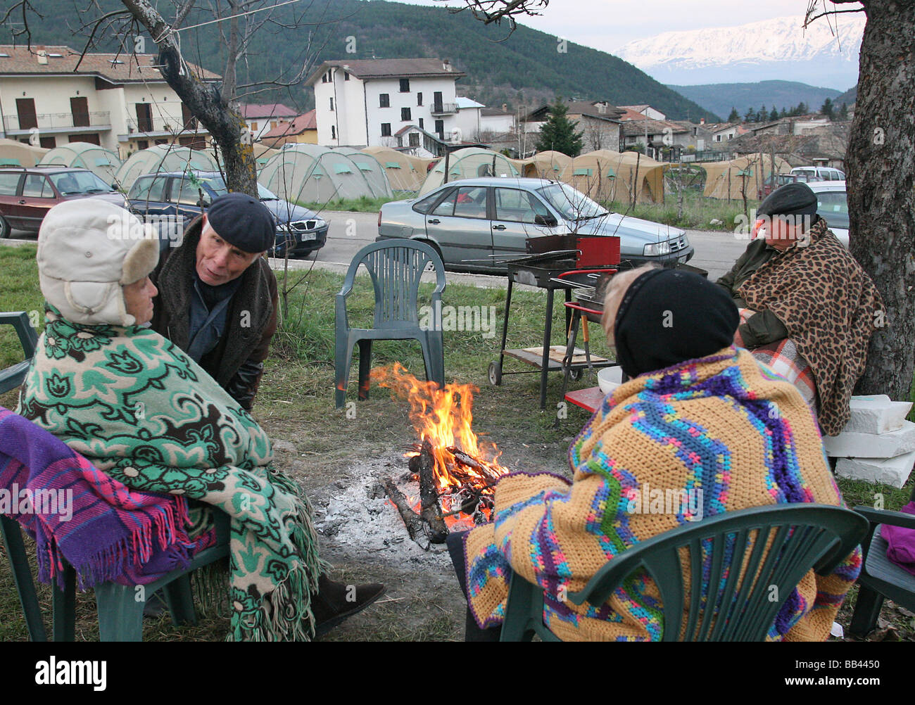 Elderly residents gather around a campfire following the earthquake of 6th April 2009 Assergi Arbuzzo Italy Stock Photo