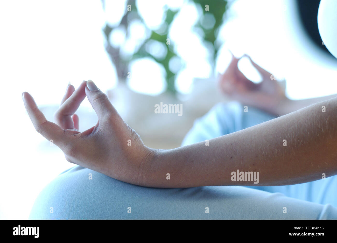 a woman meditating through yoga exercise Stock Photo