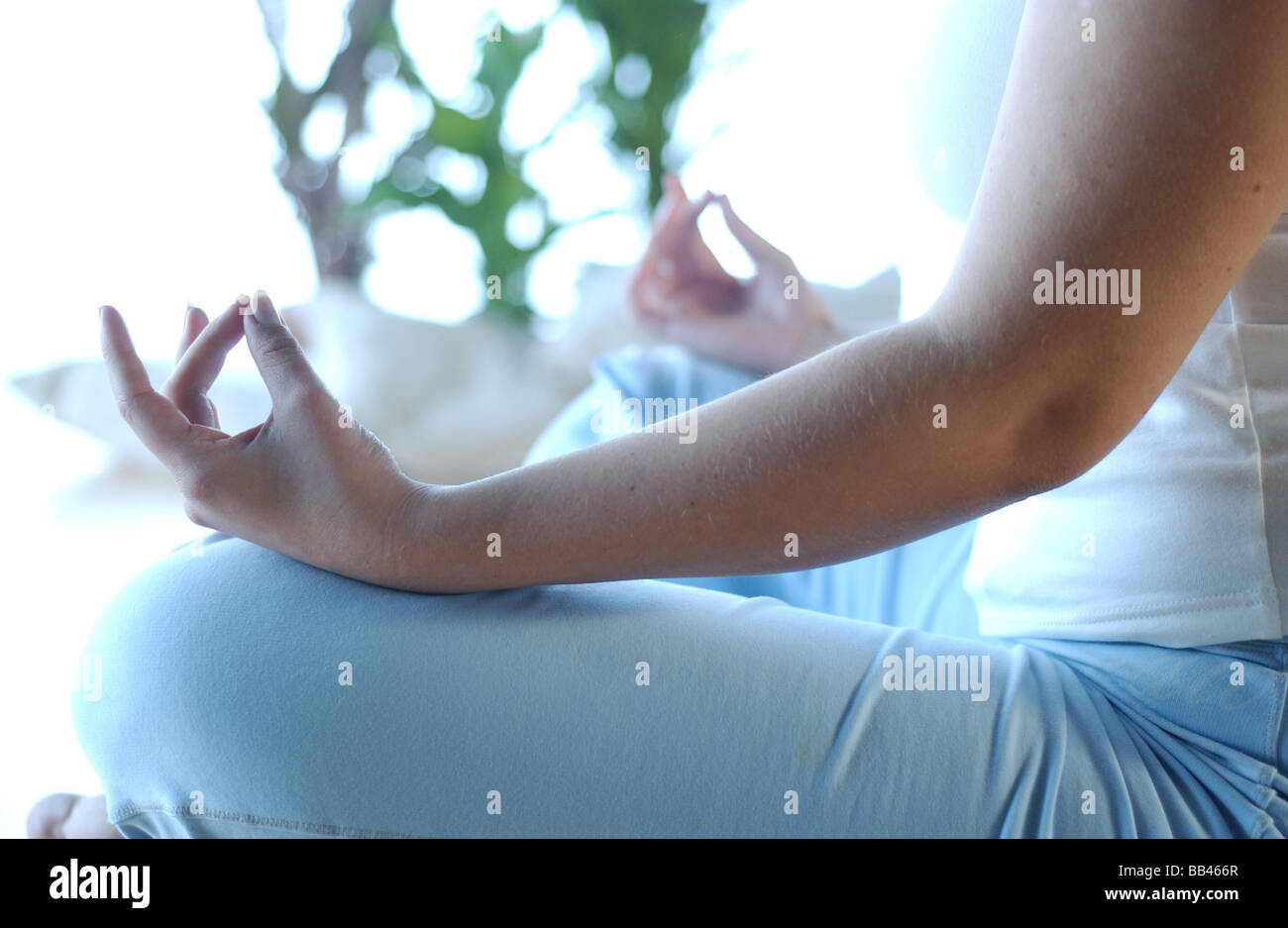 a woman meditating through yoga exercise Stock Photo