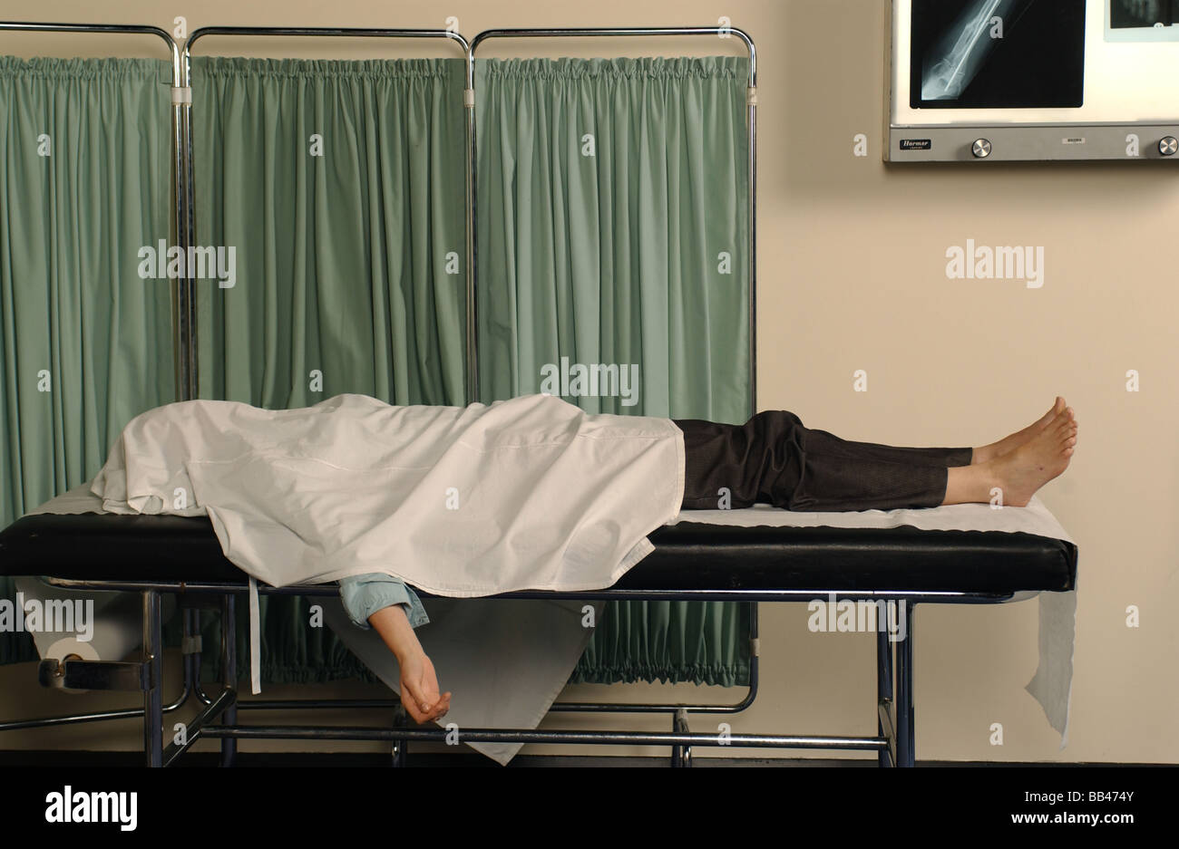 a dead body lying in a NHS hospital morgue during a COVID 19 Epidemic - posed by a model Stock Photo