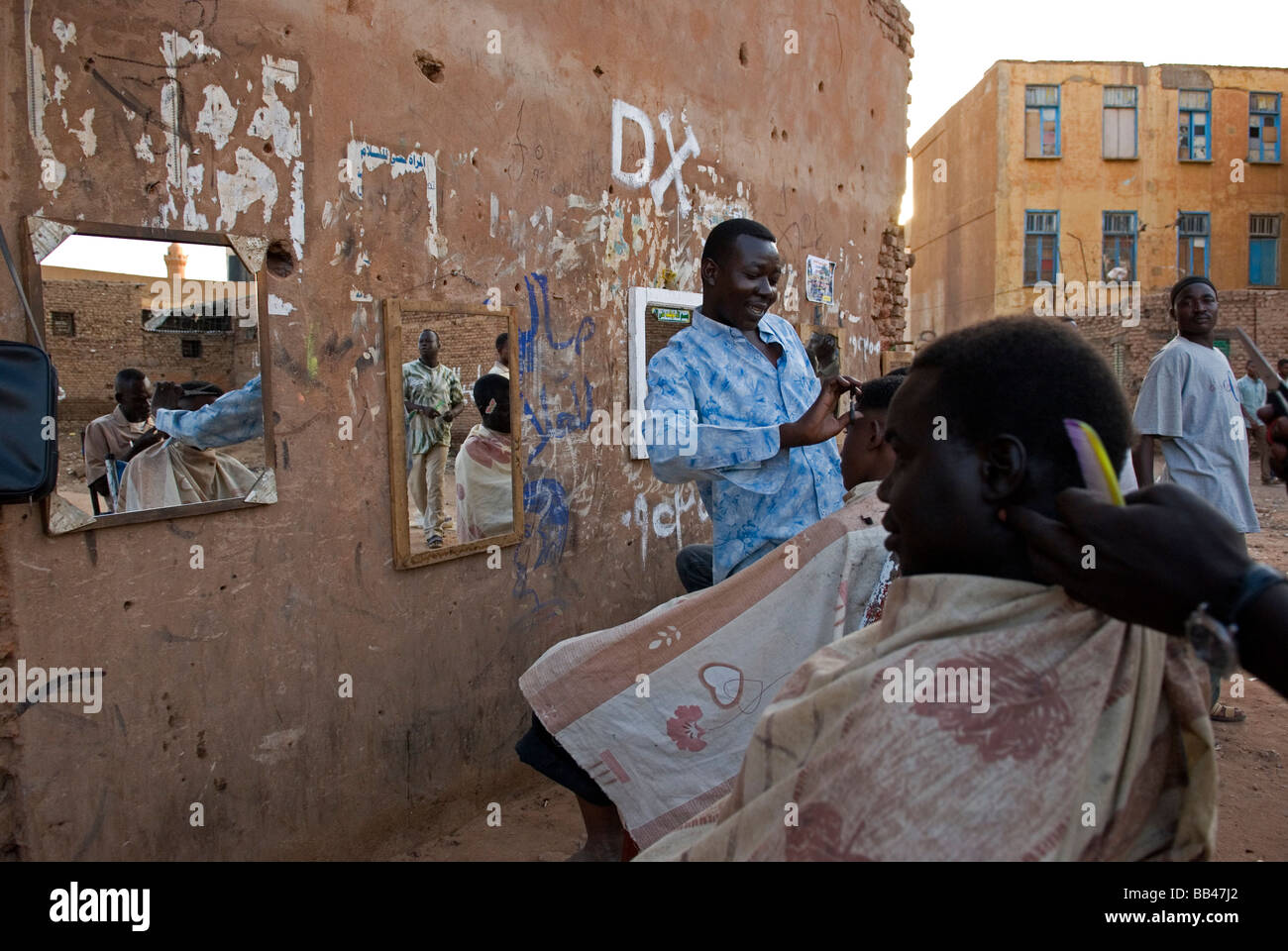 Barber giving a haircut on a street in the center of Khartoum, Sudan. Stock Photo
