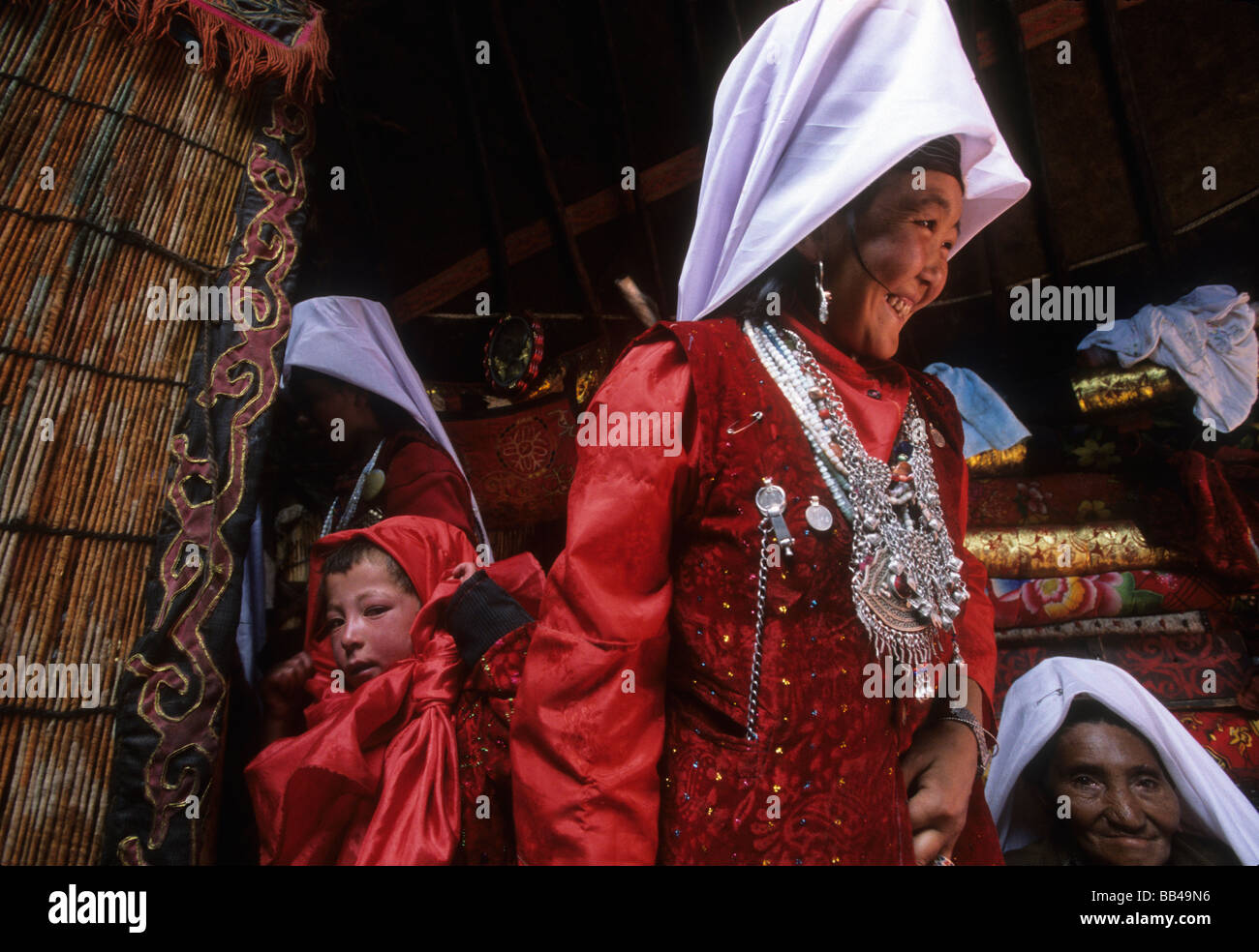 Kyrgyz women in traditional dress visit with each other inside a yurt in the Little Pamirs, Wakhan Corridor Stock Photo