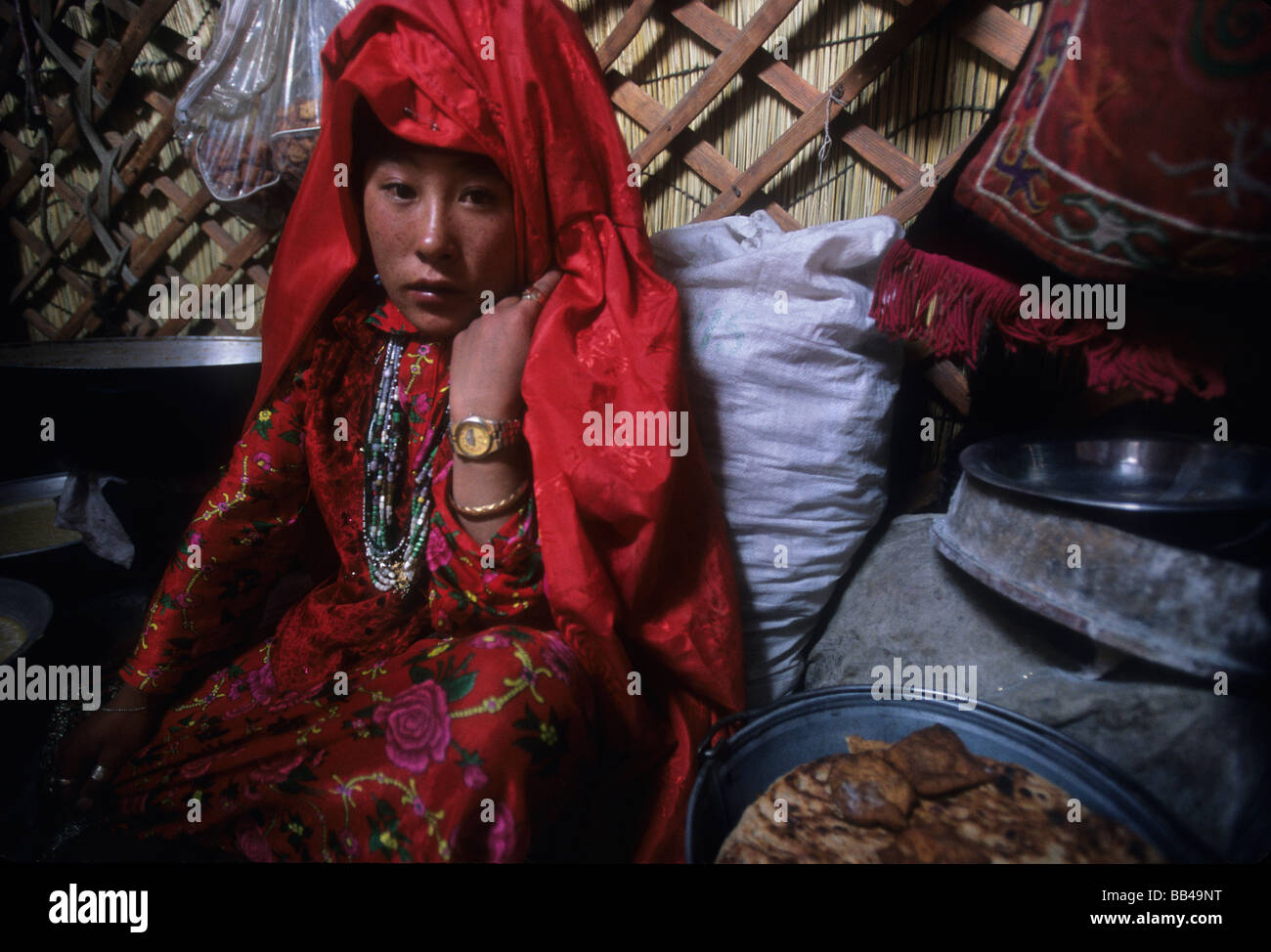 A young Kyrgyz woman in traditional dress waits for her marriage ceremony inside a yurt in the Little Pamir, Wakhan Corridor. Stock Photo
