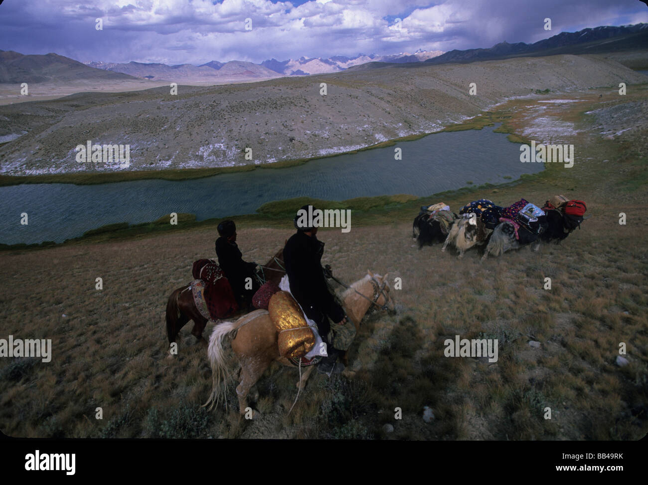 Horsemen drive loaded yaks through the steppe in the Little Pamirs, Wakhan Corridor, Badakshan Stock Photo