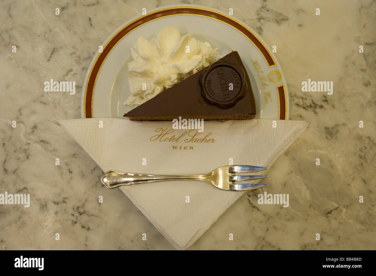 A slice of Original Sacher Torte cake with whipped cream at Hotel Sacher, Vienna, Austria Stock