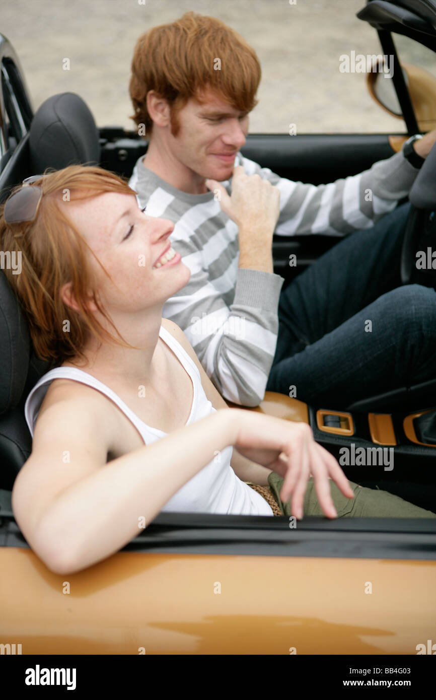 Portrait of of young couple in a car smiling Stock Photo - Alamy