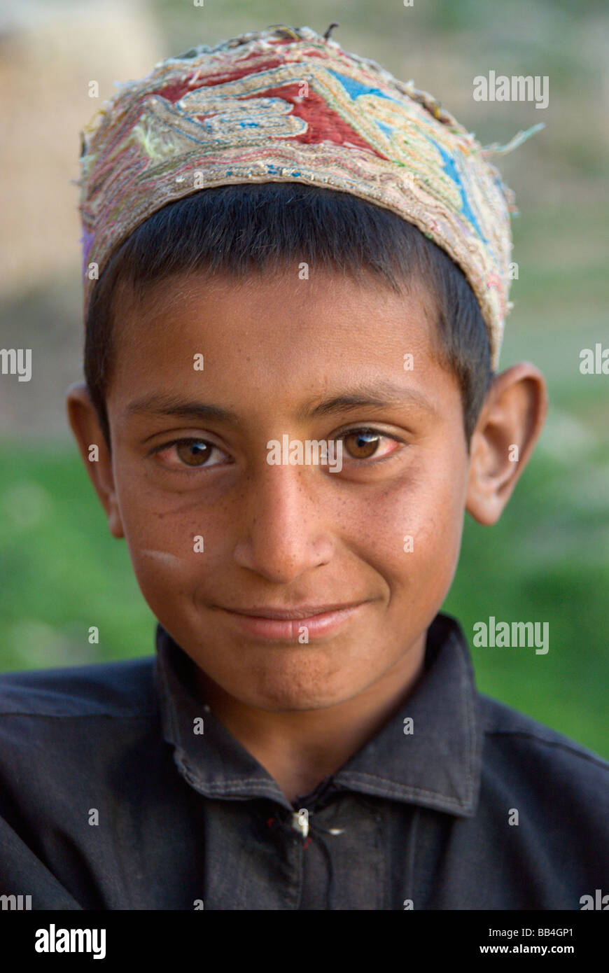 A young boy smiles shyly  in the Tajik village of Dera Jawal, at the base of the Band-e Baba range,  Herat Province Stock Photo