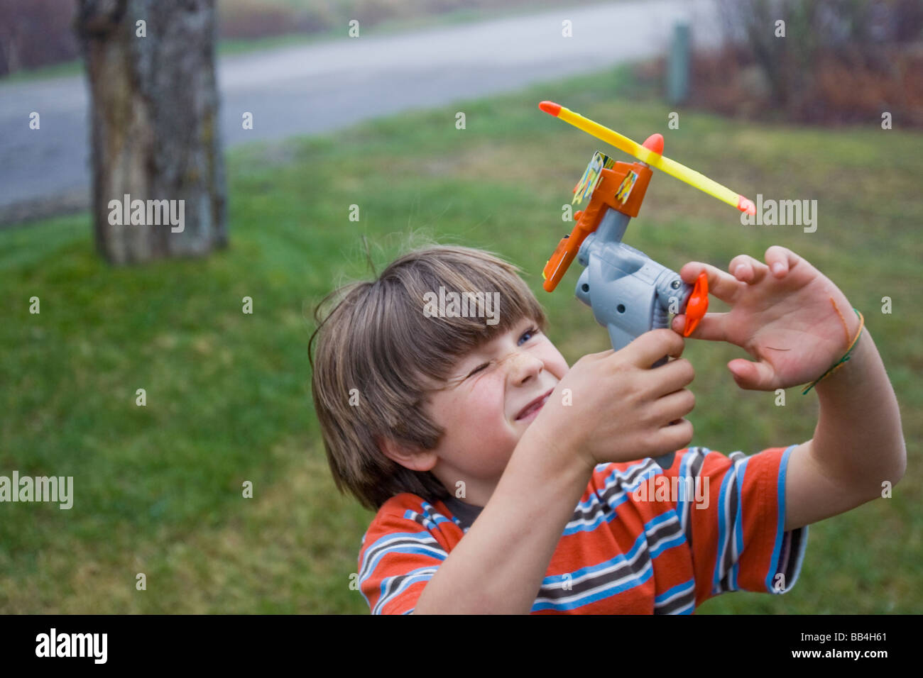 A young boy plays with a toy in his front yard in North Yarmouth, Maine