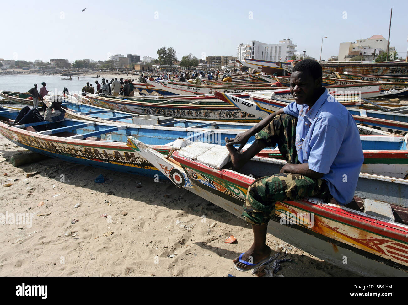 man sitting in an colorfully painted fishing boat at the fish market ...
