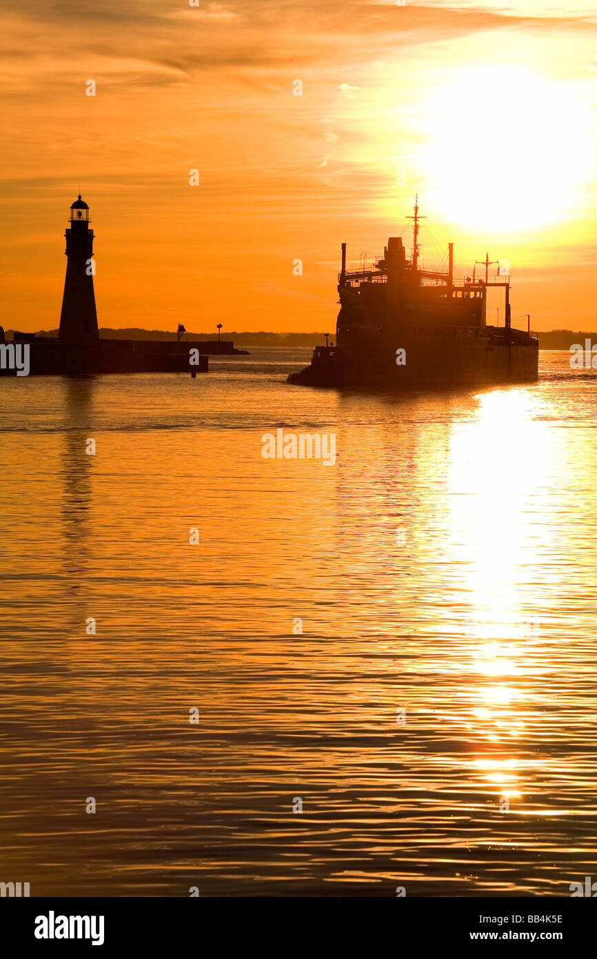 Buffalo Lighthouse and Cement Carrier in Buffalo Port at sunset; Buffalo, New York State, USA Stock Photo