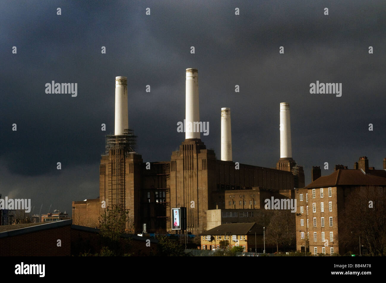 Battersea Power Station in strong sun light with dark storm clouds behind Stock Photo