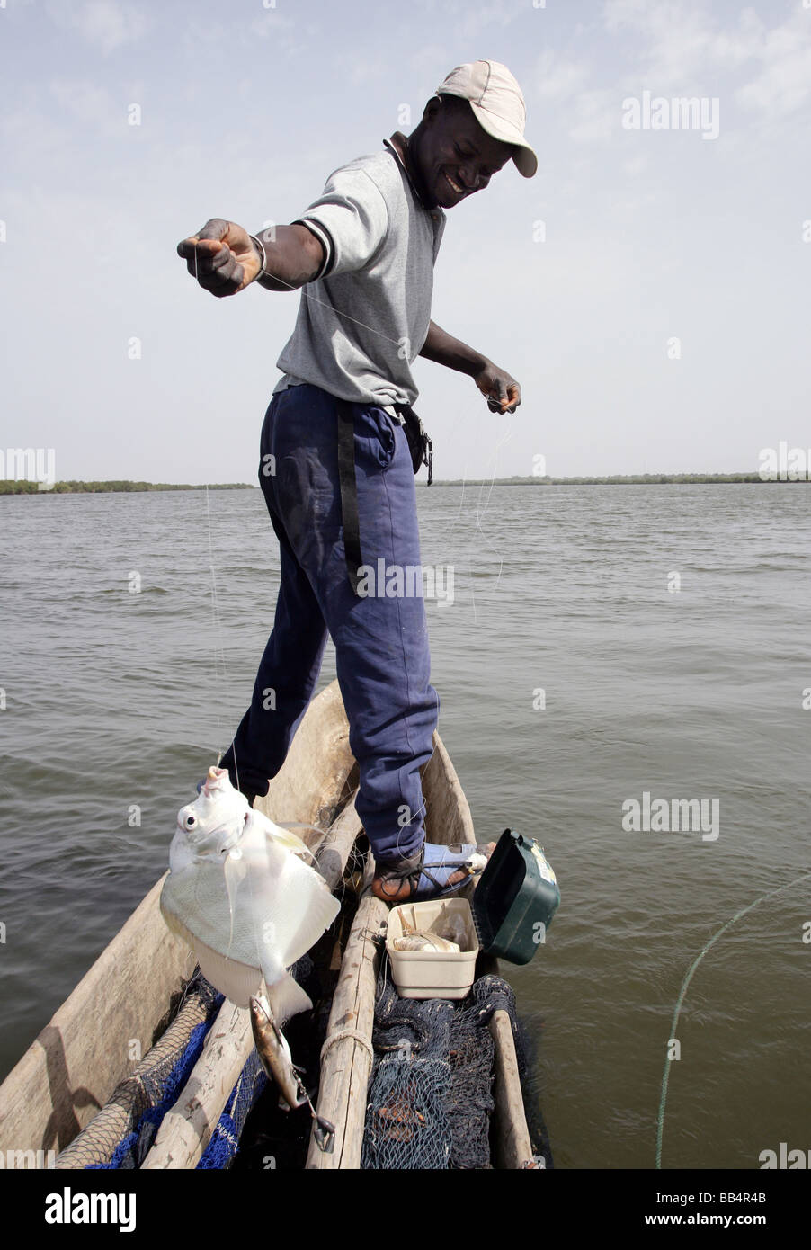 Senegal: Fisherman in his dugout canoe on the river Casamance Stock Photo