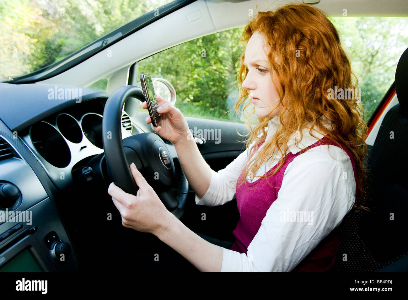 Girl texting whilst driving Stock Photo