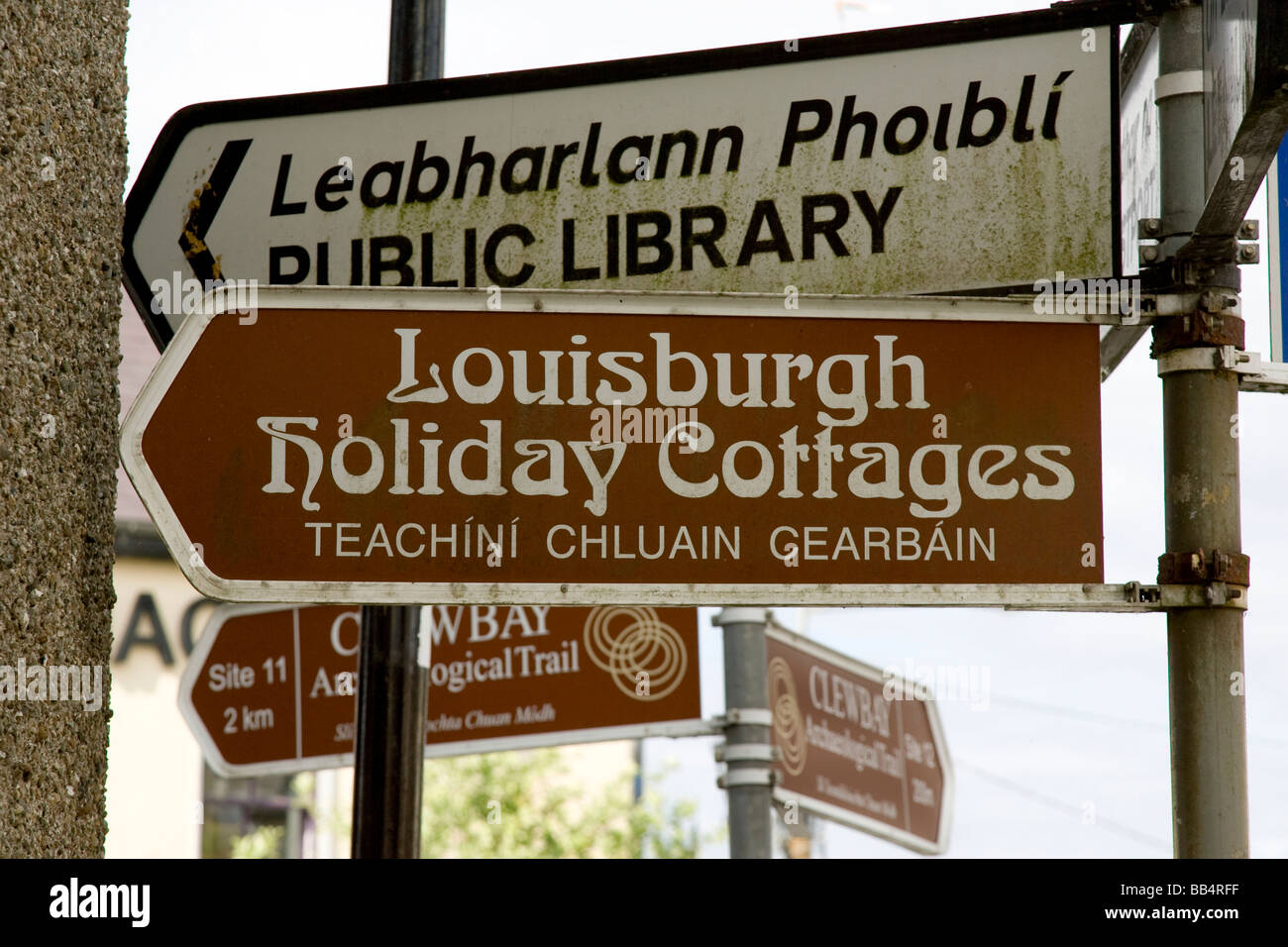 Europe, Ireland, County Mayo, Louisburgh. English and Gaelic directional signs to points of interest in the town. Stock Photo