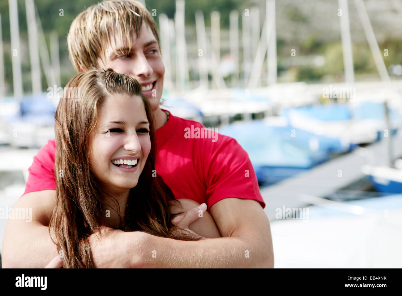 Portrait of a young couple hugging laughing at a port Stock Photo