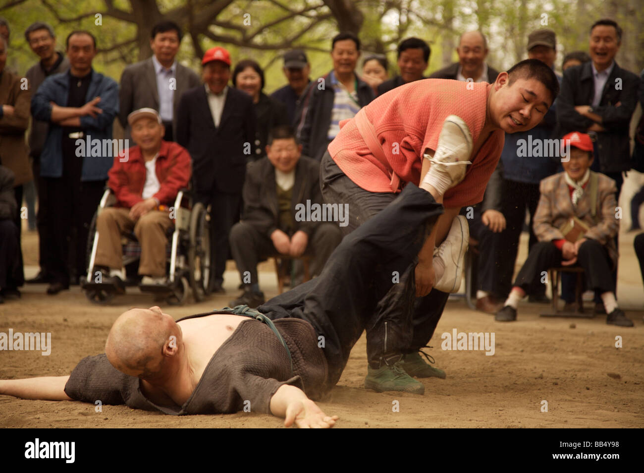 Two men wrestling in a park in Beijing Stock Photo
