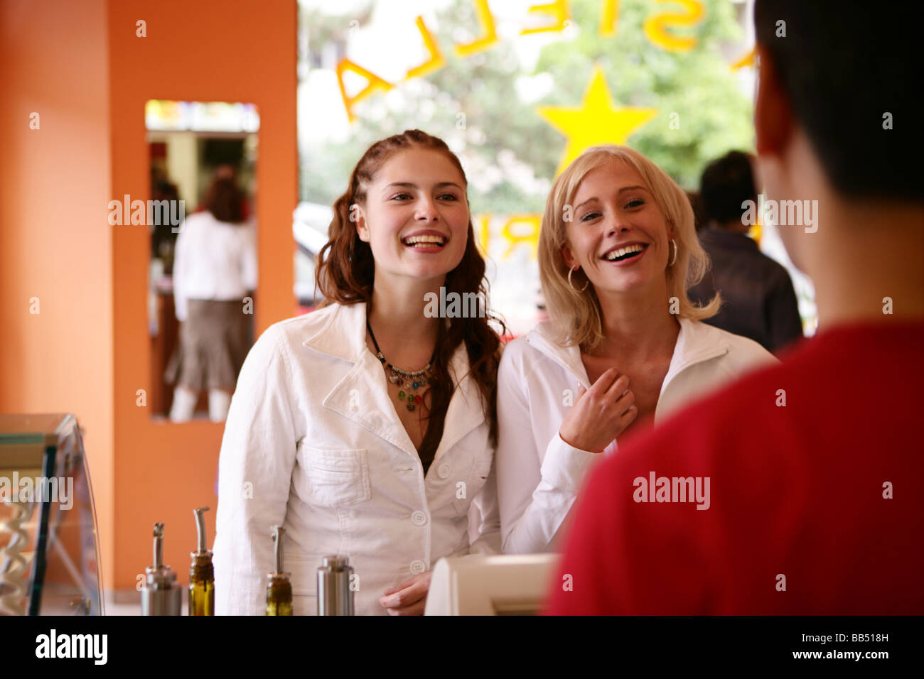 two teenager female smiling at the counter Stock Photo