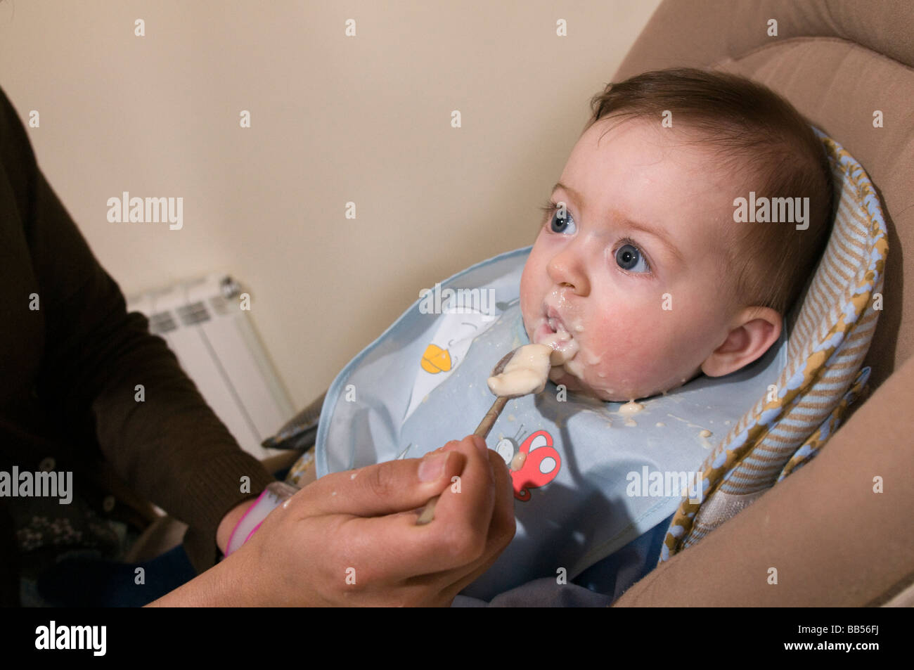 six month old baby eating baby food Stock Photo - Alamy