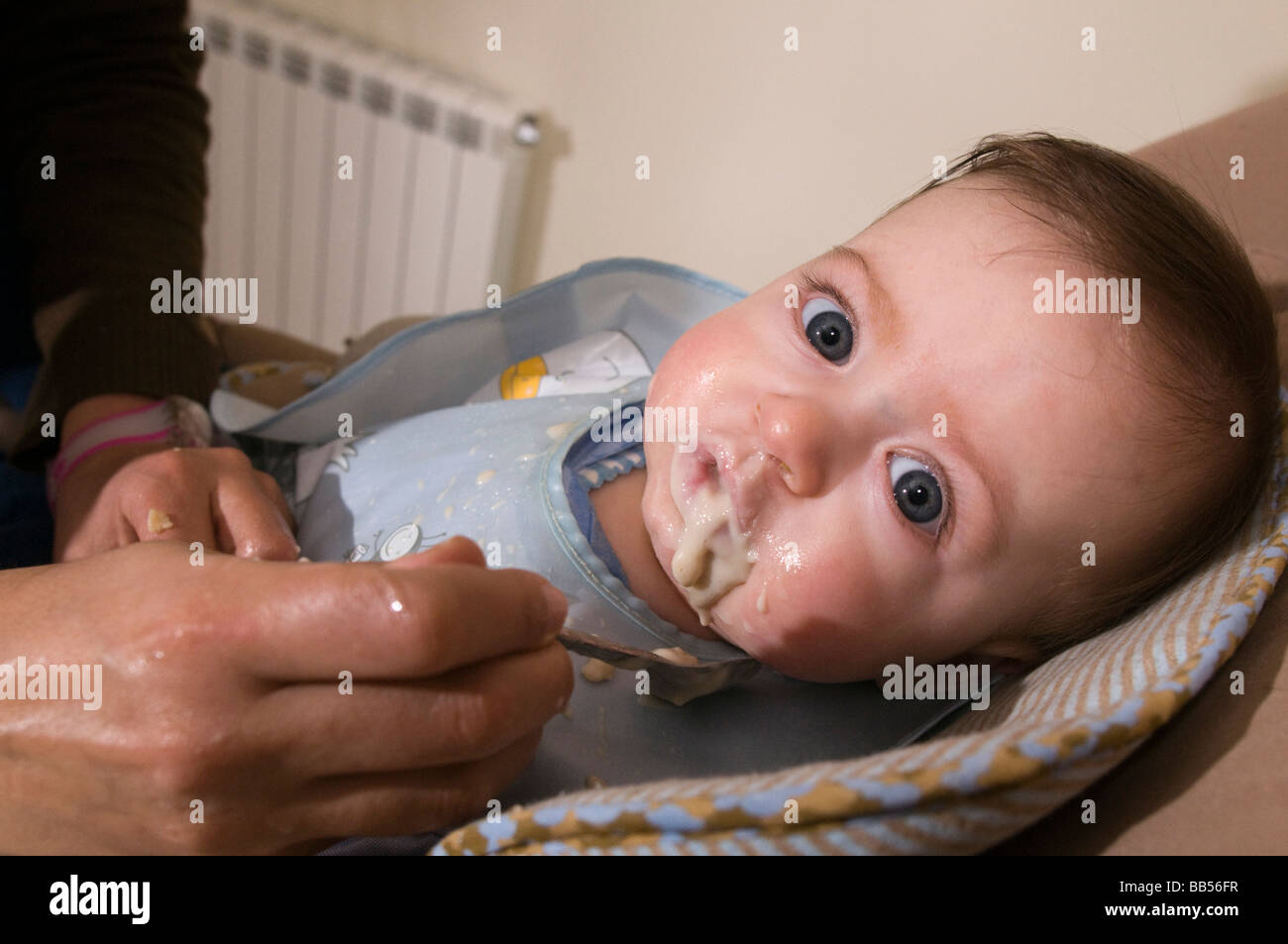 six month old baby eating baby food Stock Photo - Alamy
