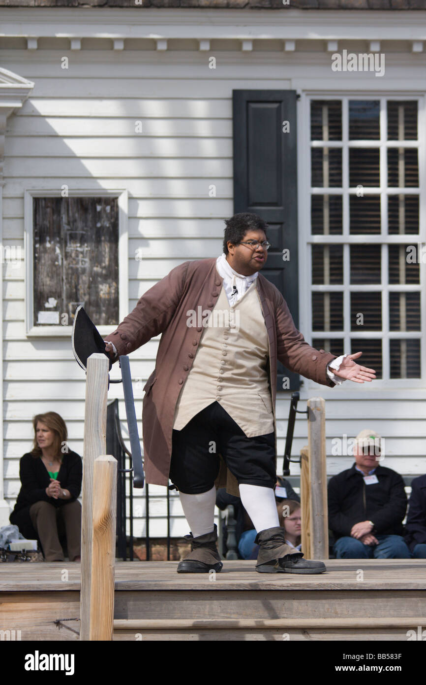 A period actor in Colonial Williamsburg, Virginia shows male visitors how to properly bow. Stock Photo