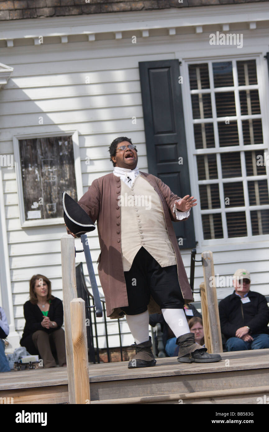 A period actor in Colonial Williamsburg, Virginia shows male visitors how to properly bow. Stock Photo