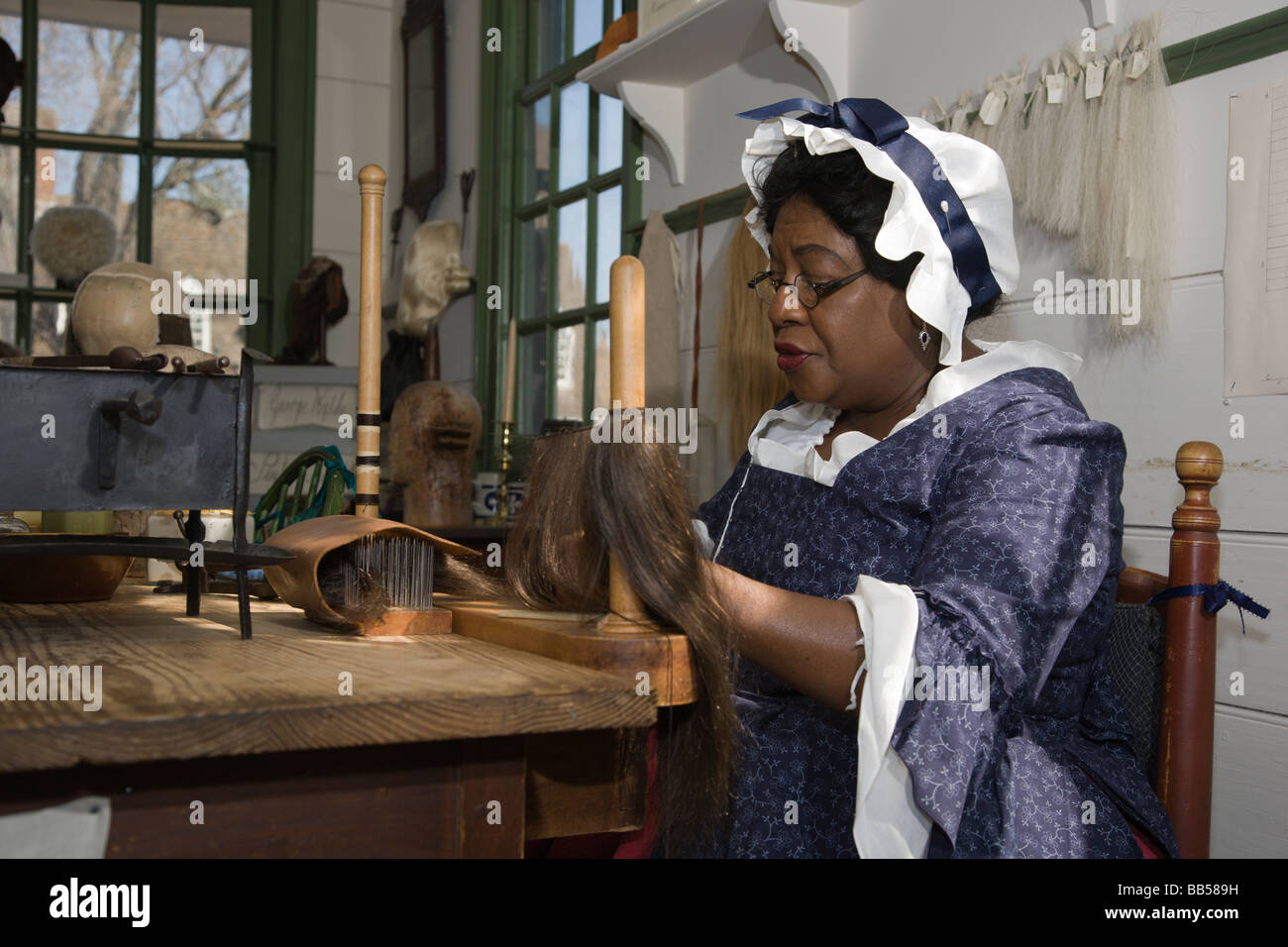 A woman makes a wig in the Barber & Peruke Maker Shop at Colonial