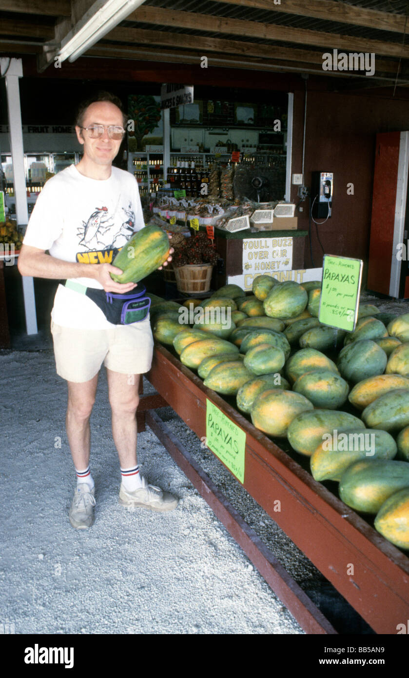 Man at farm market holding papaya fruit Stock Photo Alamy