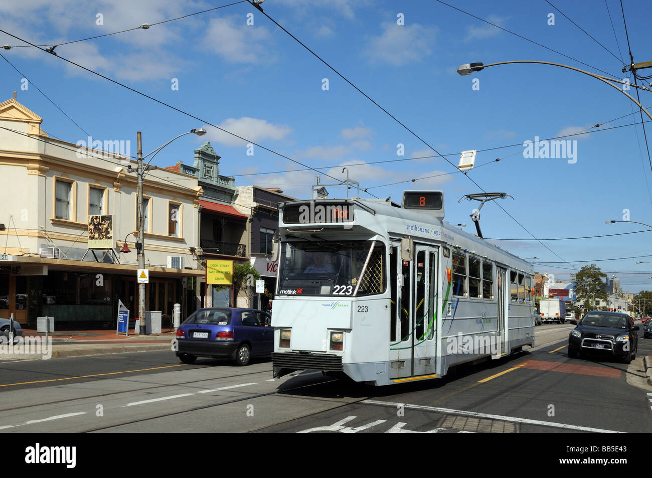 Tram passing suburban shops some with Victorian facades Lygon Street Carlton Melbourne Australia Stock Photo