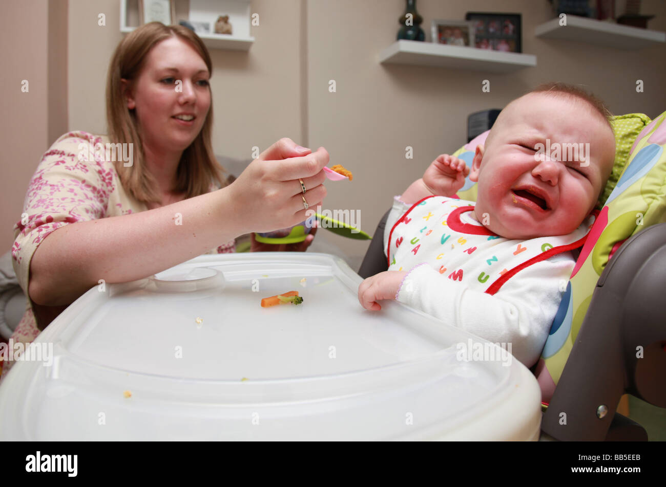 8 month old baby girl refusing to eat from spoon Stock Photo