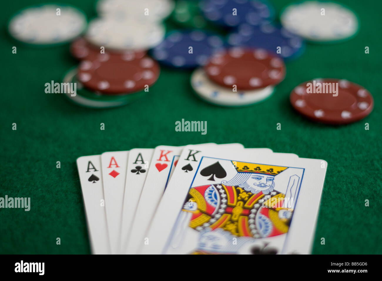 Full House Poker Hand on Green Baize with Chips Stock Photo