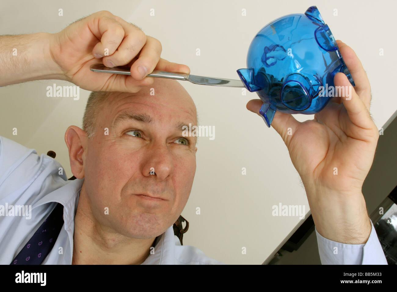 man trying to break into child's piggy bank Stock Photo - Alamy
