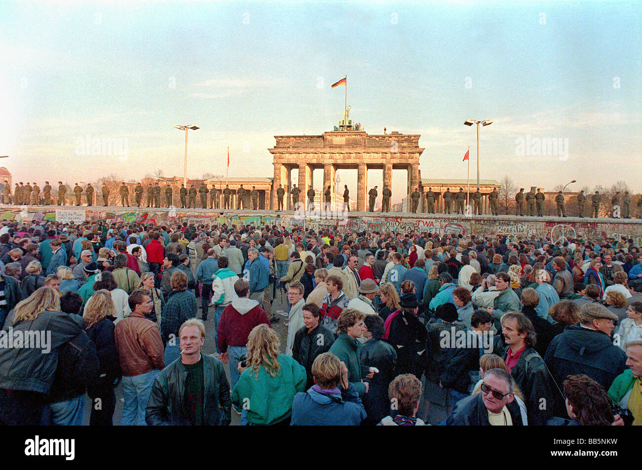Crowds in front of Berlin Wall and Brandenburg Gate in 1989, Berlin, Germany Stock Photo