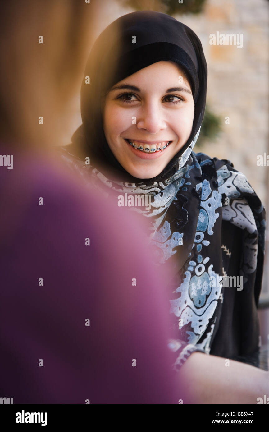 Middle Eastern teenager in headscarf talking to mother Stock Photo