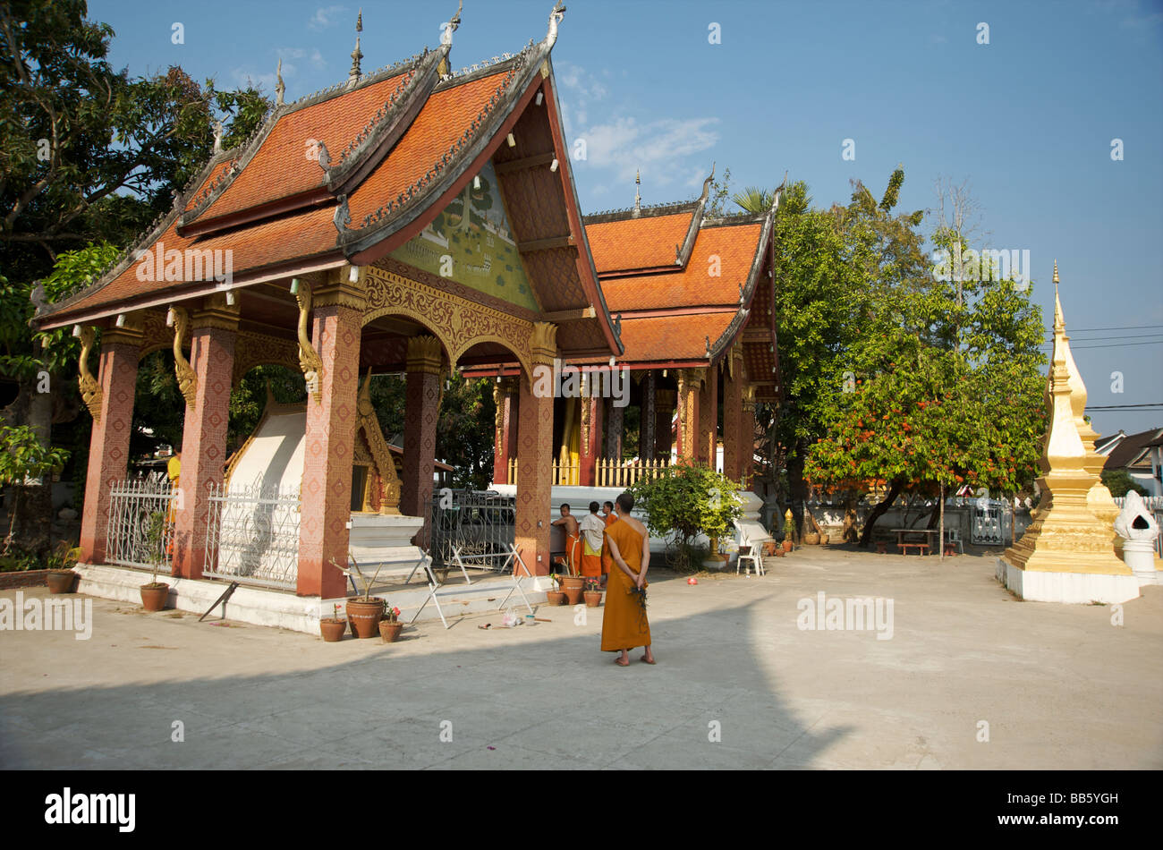 Monks go about their daily chores of temple cleaning and maintenance in their Buddhist temple Luang Prabang Laos Stock Photo