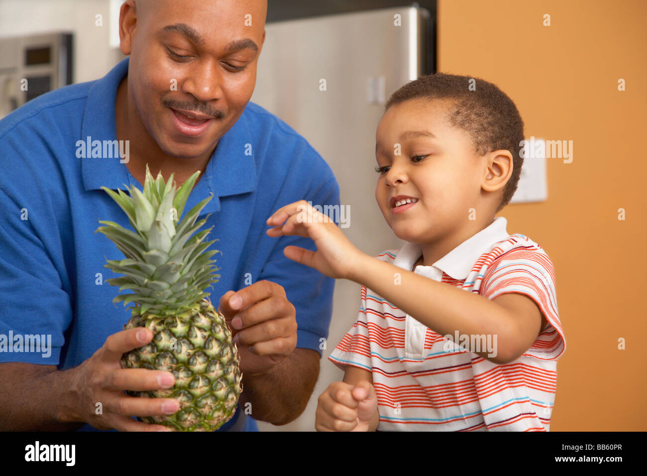 Antiguan father showing pineapple to son Stock Photo