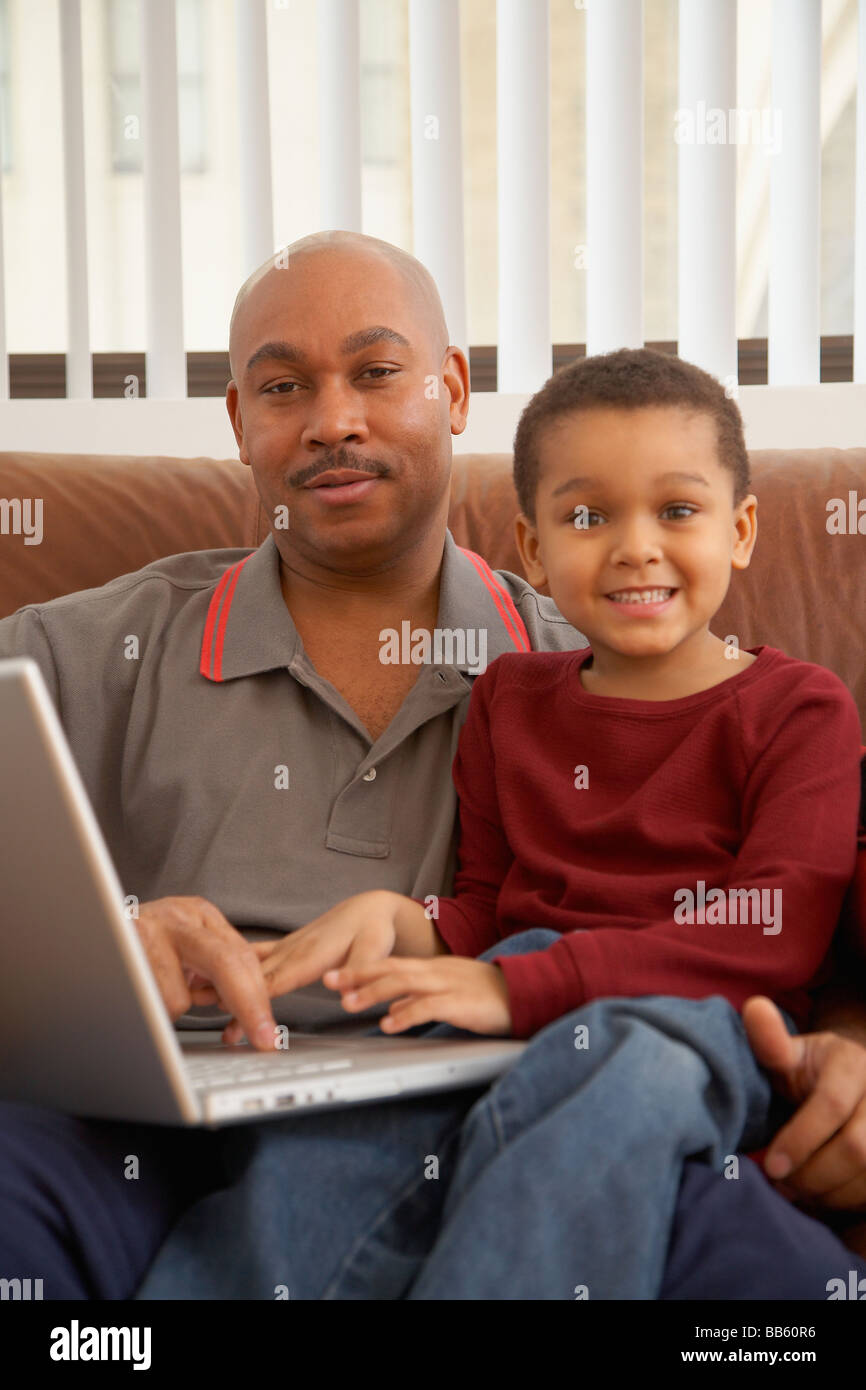 Antiguan father using laptop with son Stock Photo