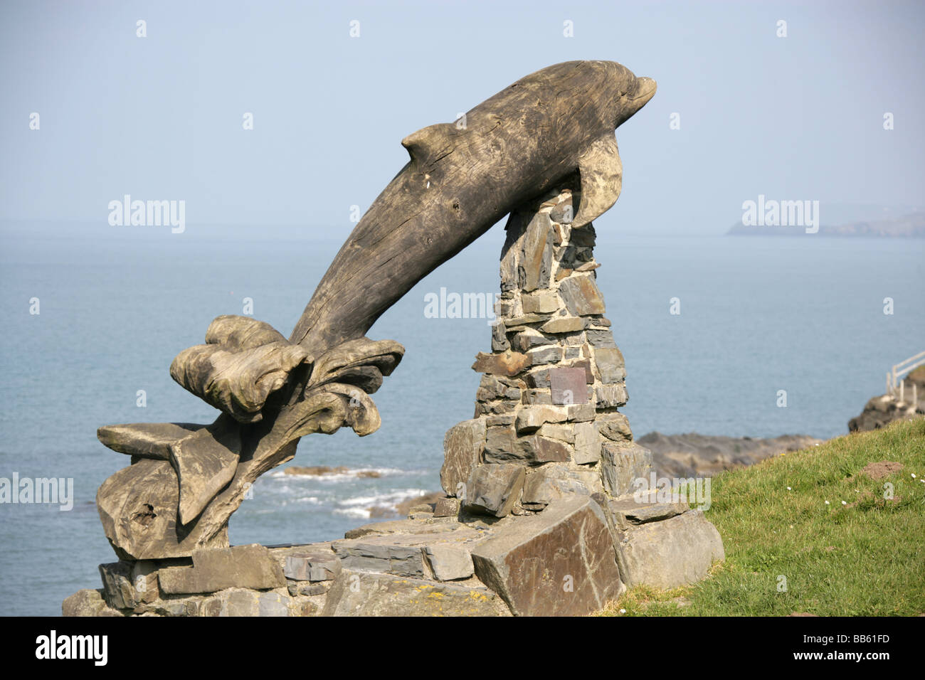 Village of Aberporth, Wales. The Paul Clarke designed and carved Leaping Dolphin sculpture overlooking Aberporth coastline. Stock Photo