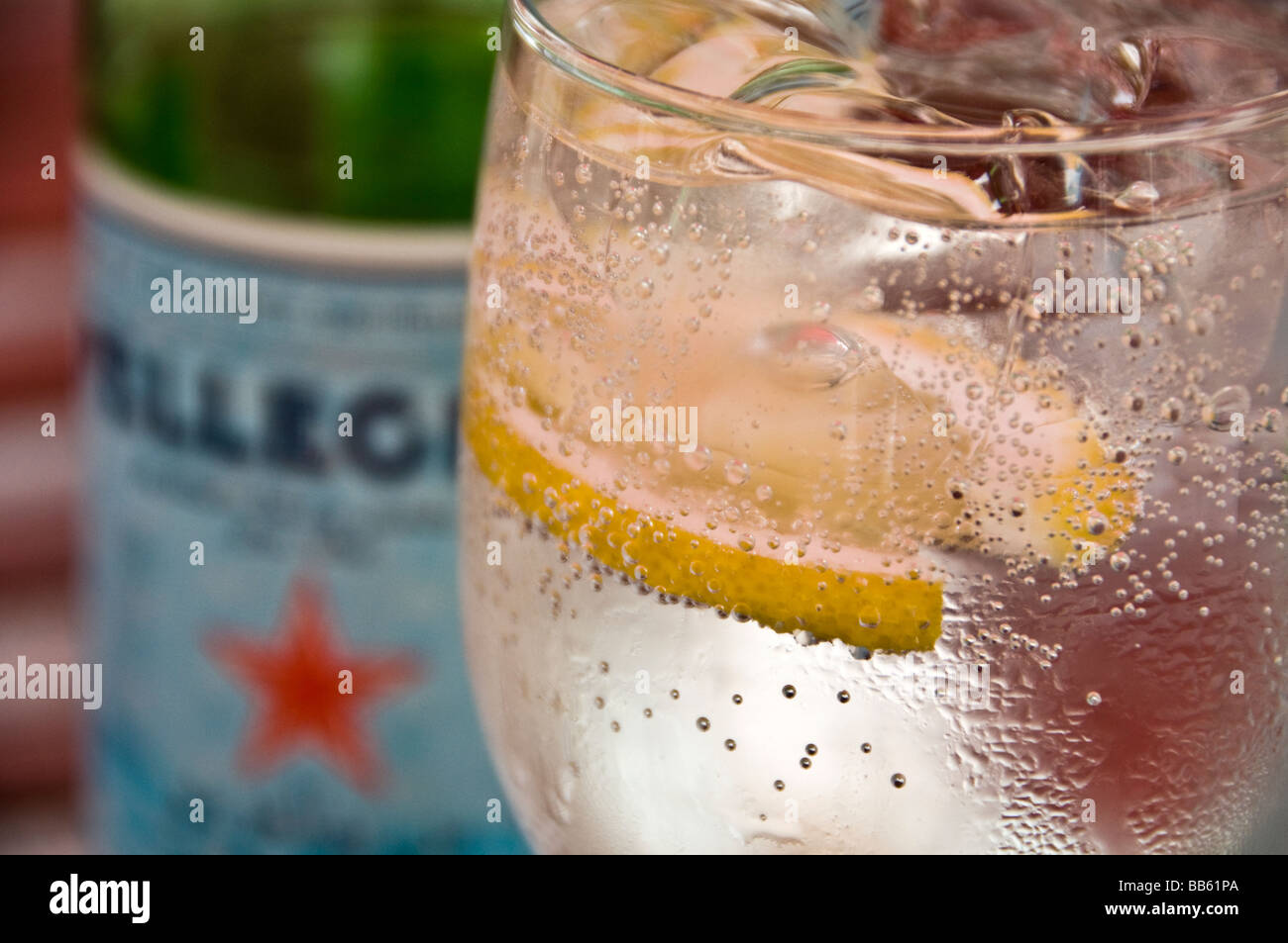 Sparkling mineral water in a glass with ice and lemon Stock Photo