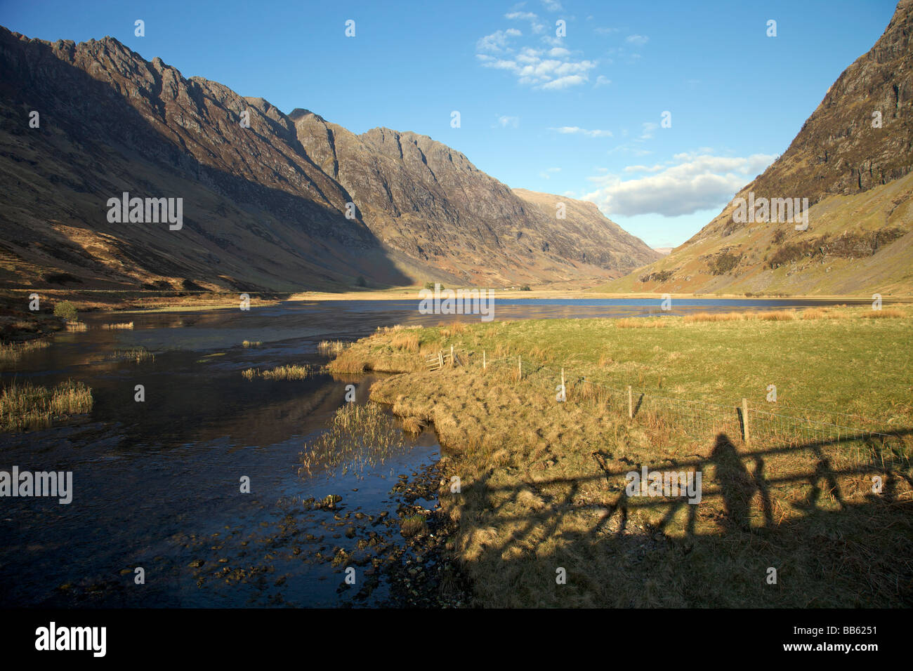 Shadow of the bridge over Loch Achtriochtan at the foot of the Pass of Glencoe in early evening sunlight Stock Photo