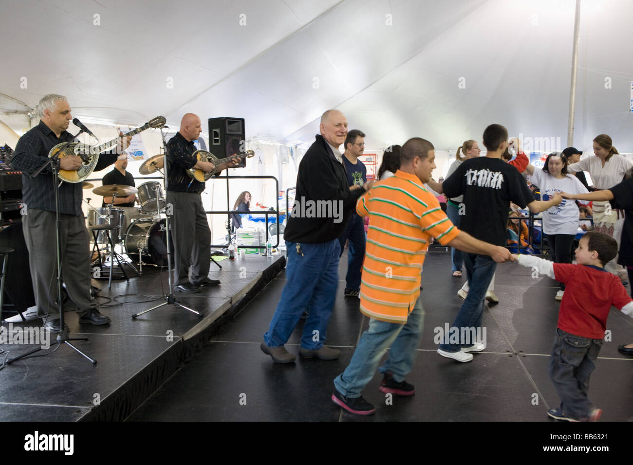 People dancing traditional while men play bouzouki at Greek Festival
