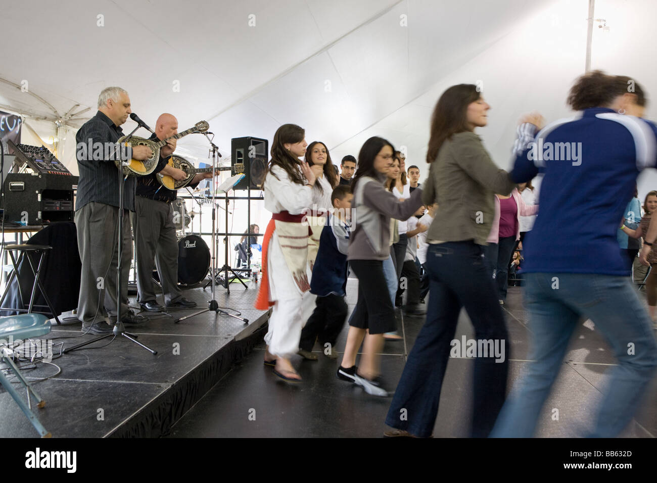 People dancing traditional while men play bouzouki at Greek Festival