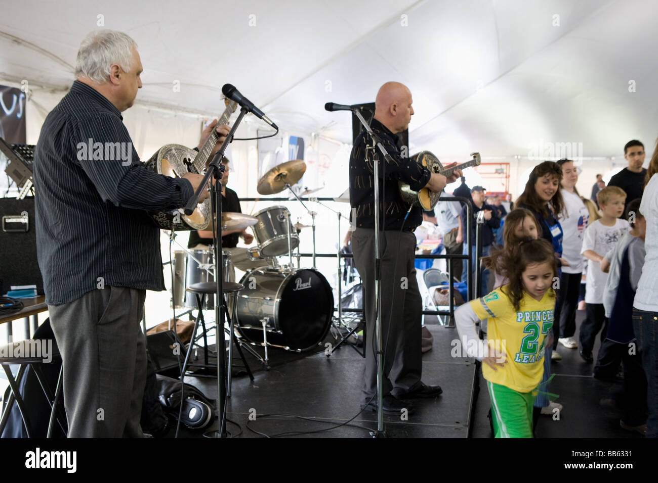 People dancing traditional while men play bouzouki at Greek Festival